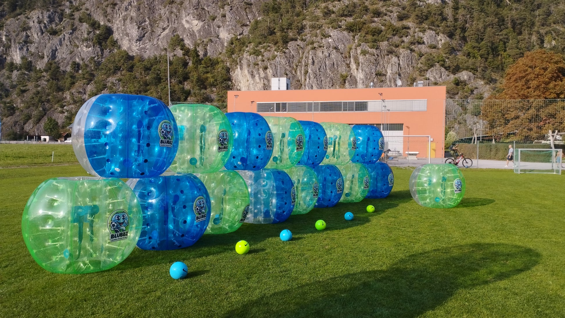 Bubble Soccer am Sportplatz Pettnau, Tirol, Österreich. Ausrüstung der Fußball Freizeitaktivität Seitenansicht 