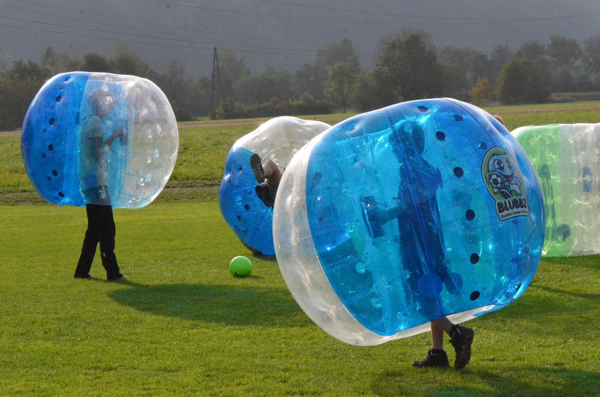 Bubble Soccer am Sportplatz Pettnau, Tirol, Österreich. Momentaufnahme von mehreren Fußballspielern